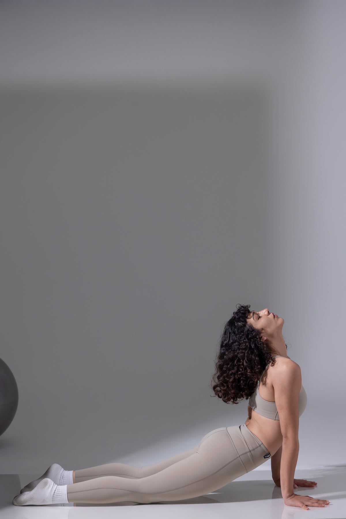 Woman in a yoga pose on a plain background