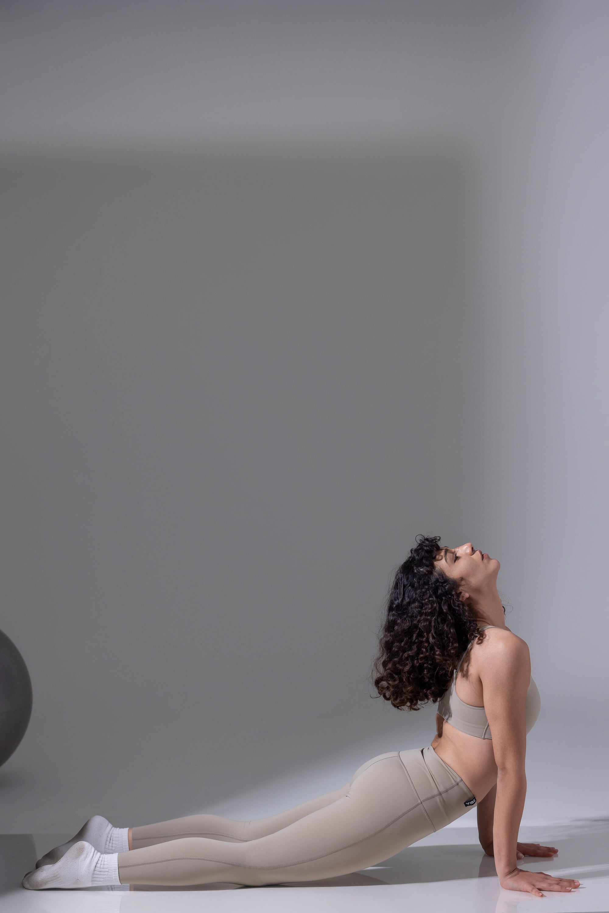 Woman in a yoga pose on a plain background